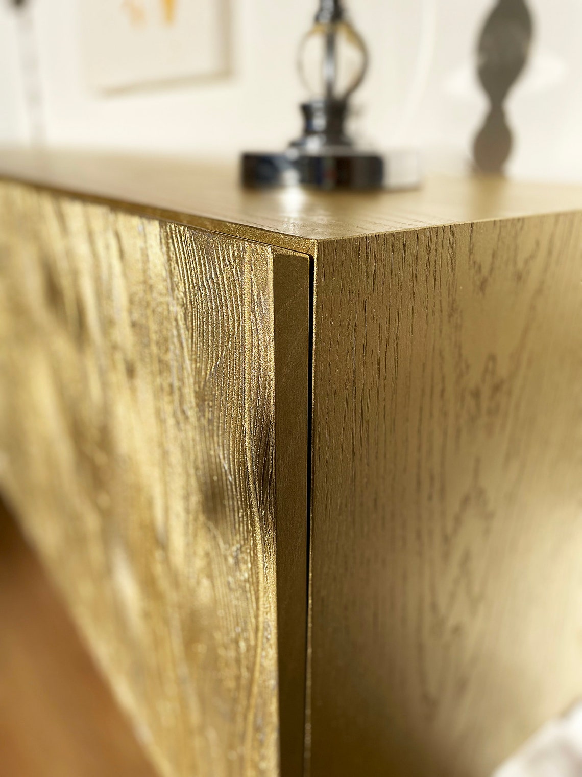 Close-up of a wooden console table with a gold finish.