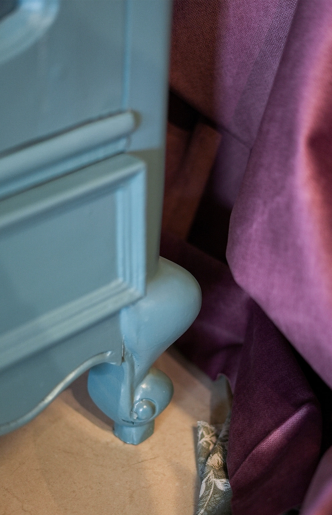 Light blue radiator against a pink curtain