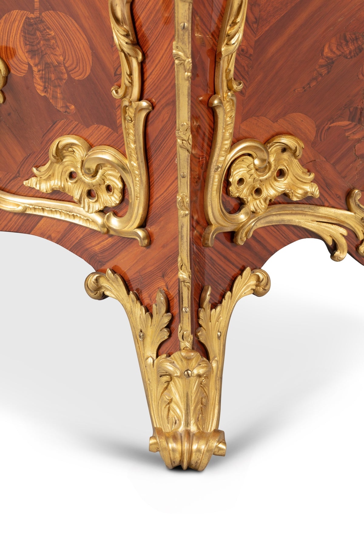 Close-up of a wooden furniture piece with gold decorative elements on a white background
