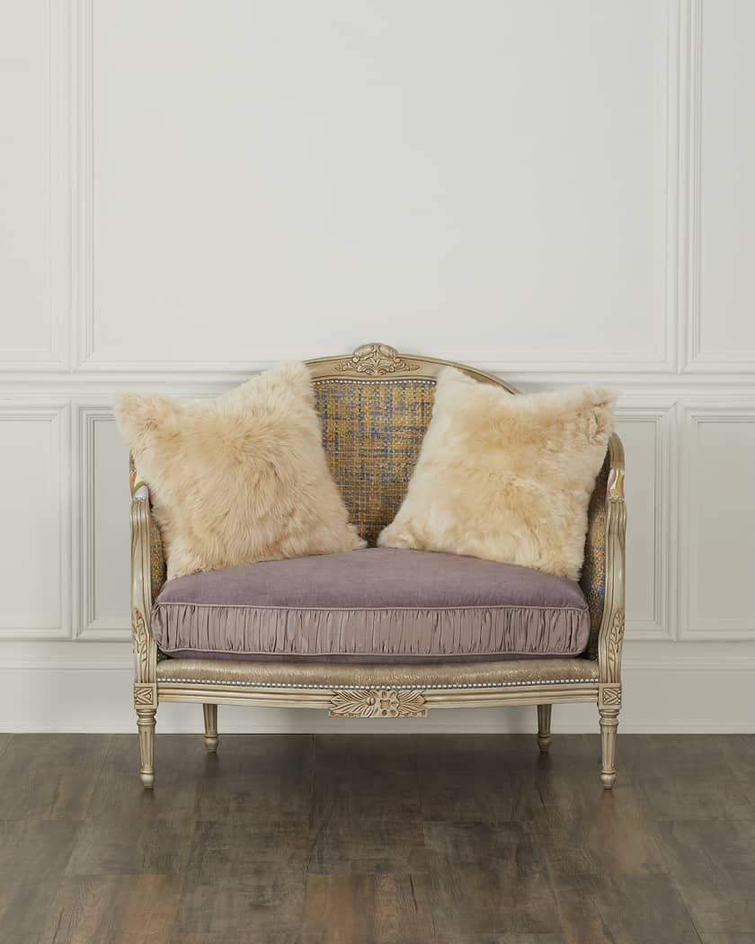 Vintage-style chair with fur cushions against a white paneled wall.