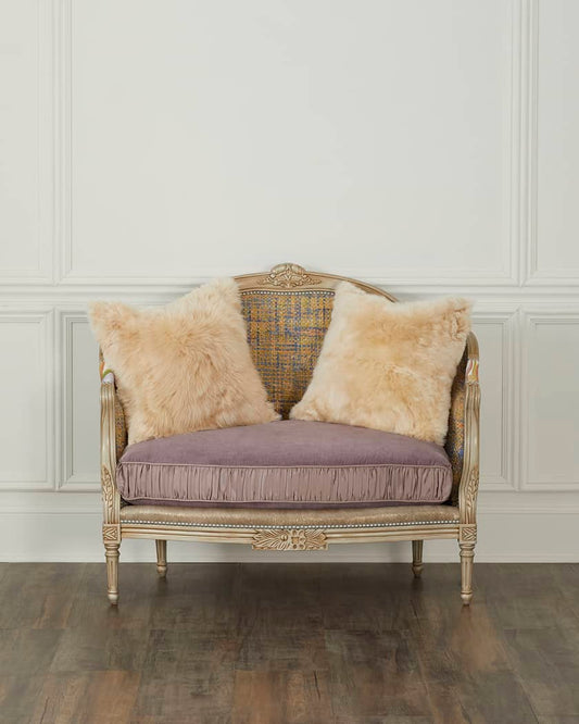 Vintage-style chair with fur cushions against a white paneled wall.