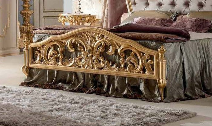 Decorative gold bed frame with intricate designs in a bedroom setting.