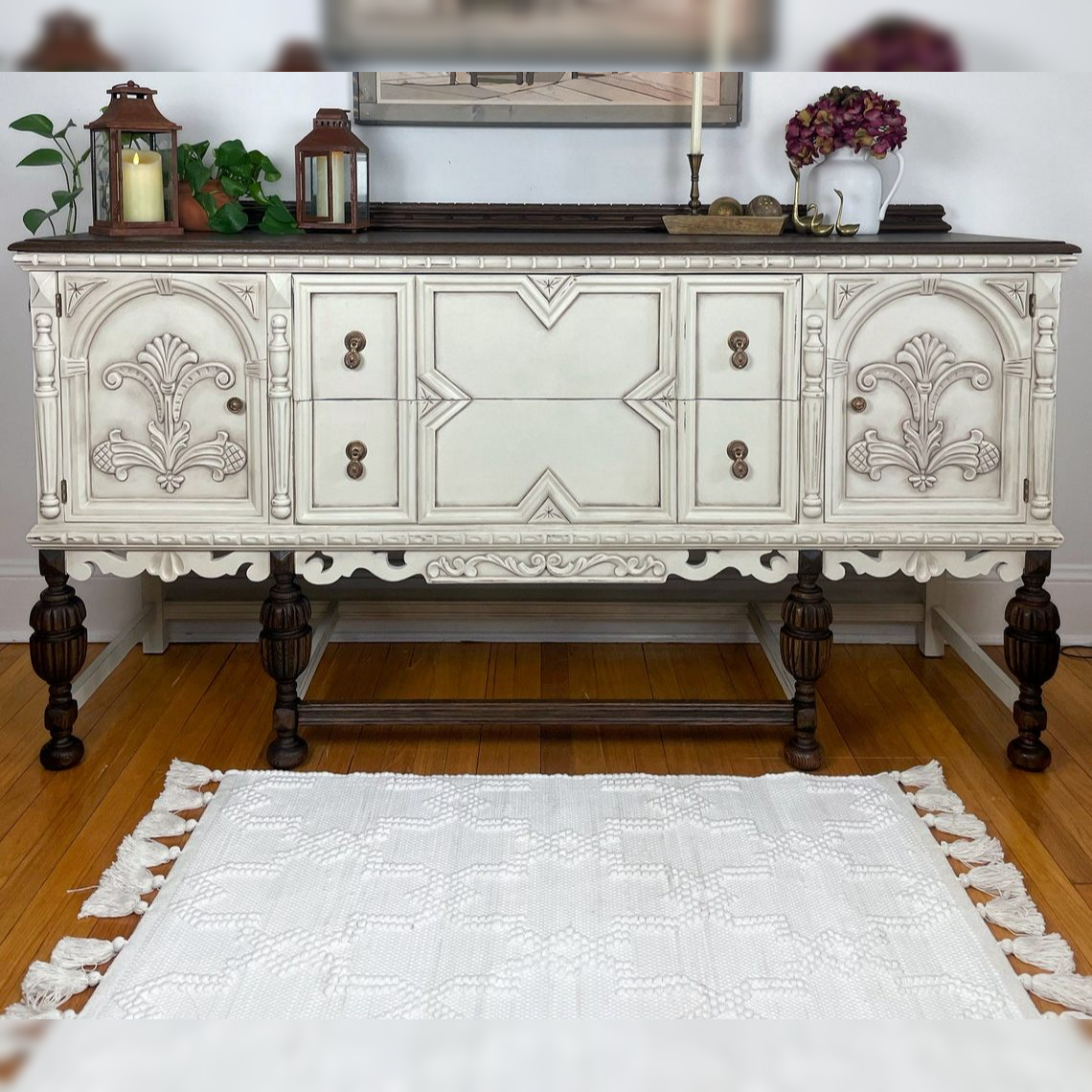 Decorative white sideboard with intricate carvings on a wooden floor.