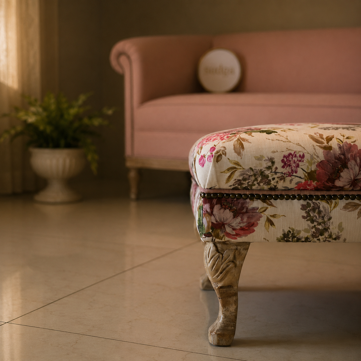 Floral-patterned ottoman in a living room with a pink sofa and plant in the background.