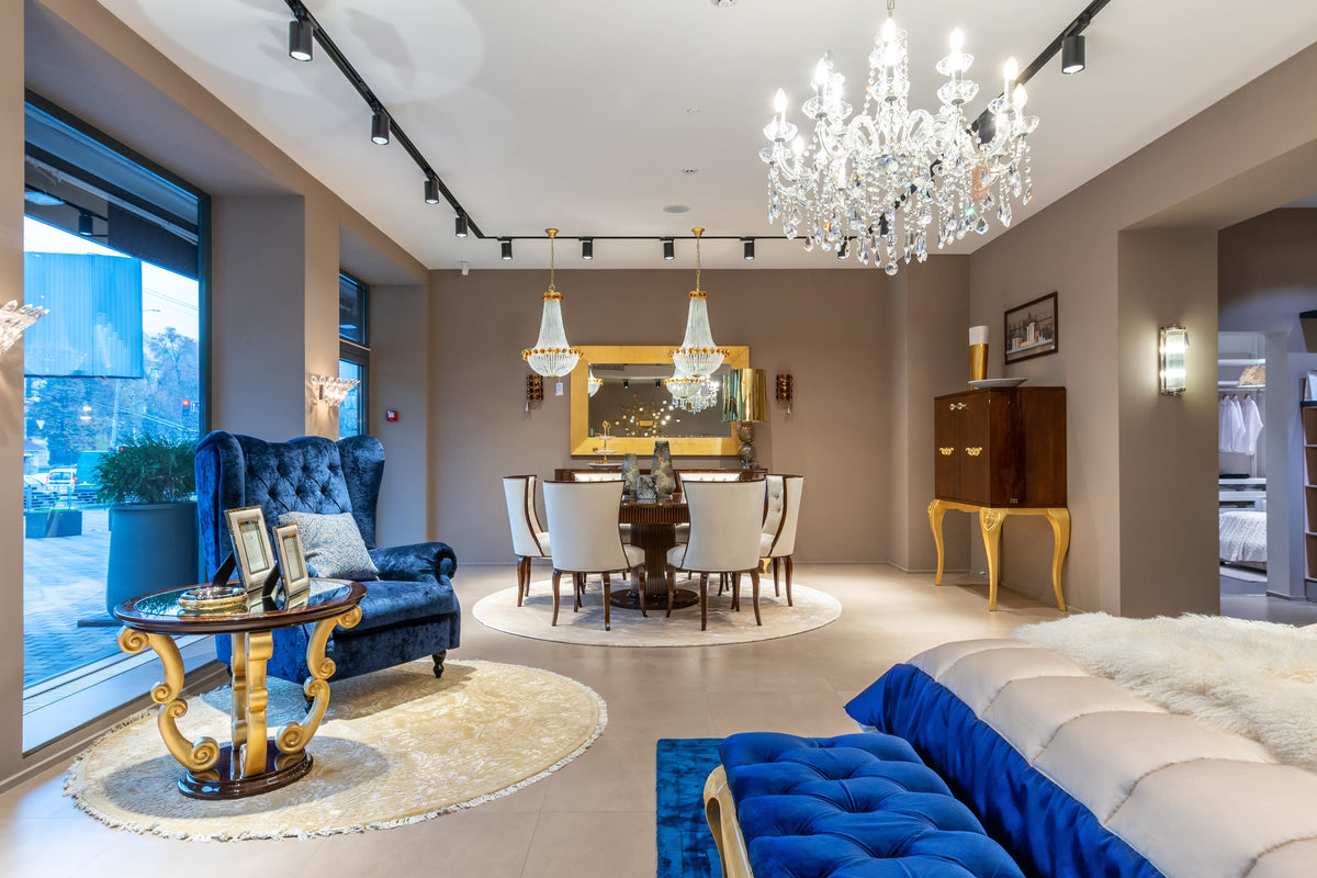 Luxurious living room with chandeliers, furniture, and large windows.