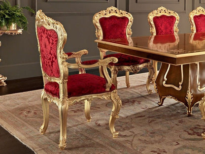 Dining table set with red chairs and gold frames in a formal dining room.