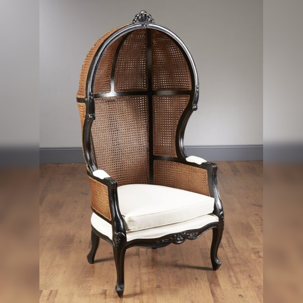 Decorative chair with wicker back and white cushion on a wooden floor.
