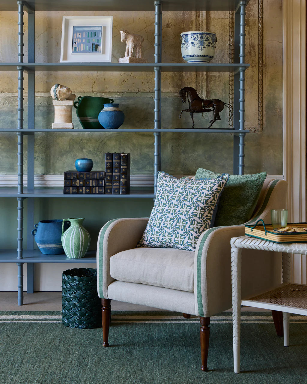 Living room with a bookshelf, armchair, and decorative items.