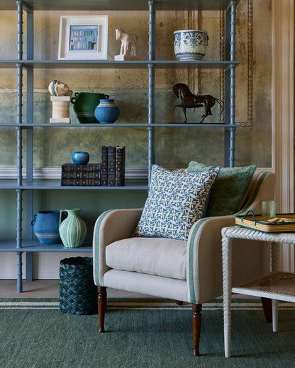 Living room with a bookshelf, armchair, and decorative items.