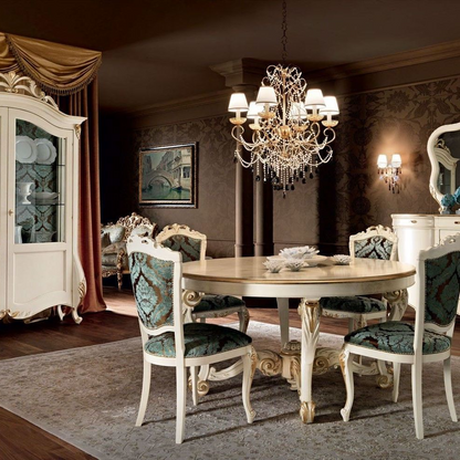 Dining room with round table and ornate chairs, featuring a chandelier and decorative wall art.
