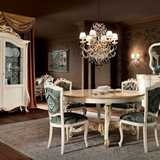 Dining room with round table and ornate chairs, featuring a chandelier and decorative wall art.