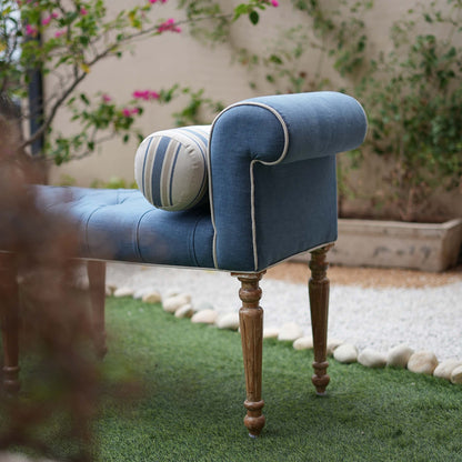 Blue tufted bench with wooden legs in an outdoor setting