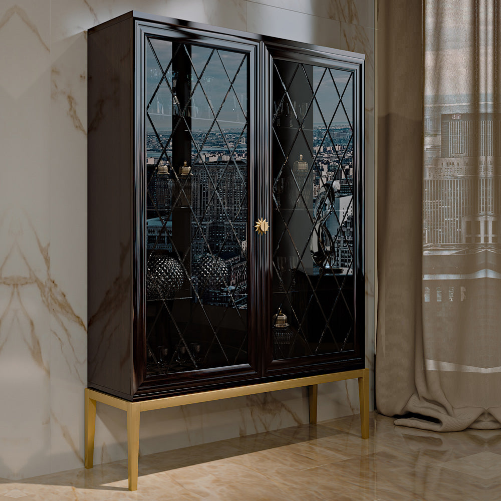 A dark brown display closet with black glass panels and gold accents, including gold feet and knobs, standing in a room with a cityscape background.