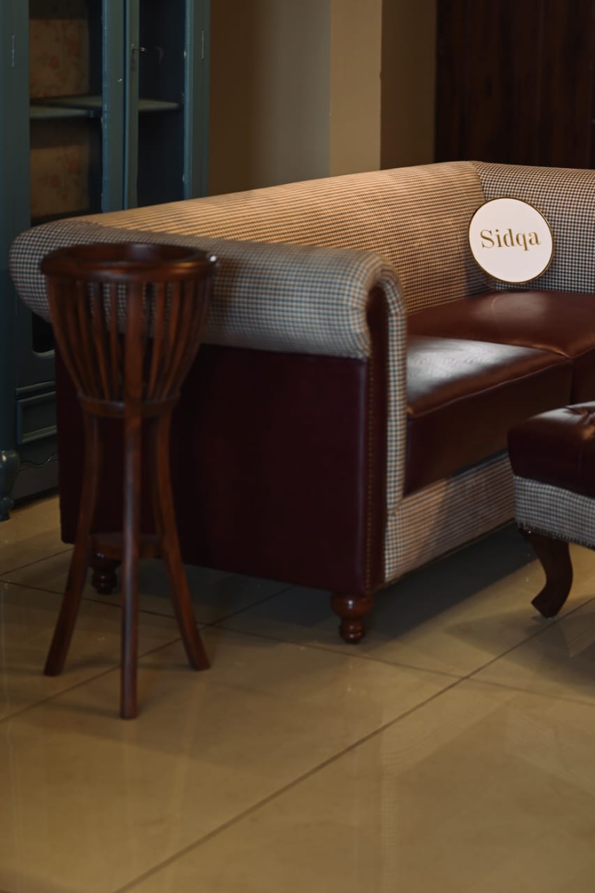 Brown leather and wicker bench with a wooden chair in a room setting.