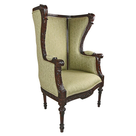 Antique green high armchair with intricate carvings on the frame and seat upholstery.