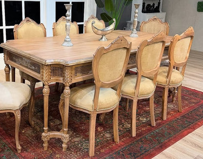 Wooden dining table with chairs in a room with a large window.