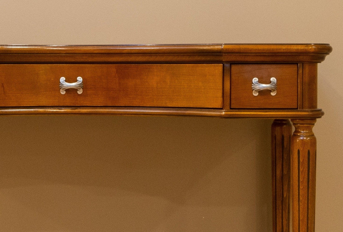 Wooden console table with two drawers against a beige wall