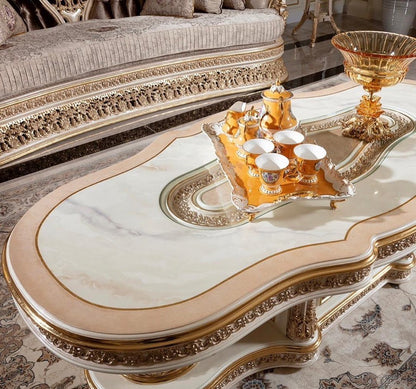 Decorative coffee table with ornate design and gold accents in a room setting.
