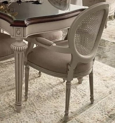 Chair with wicker backrest and cushioned seat in front of a dining table.