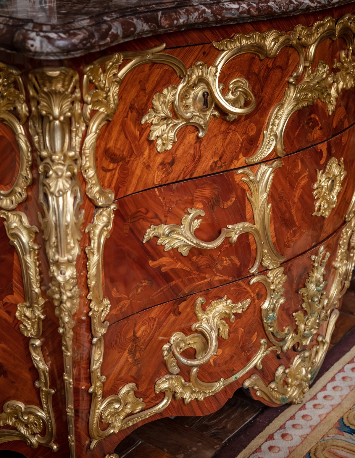 Close-up of a wooden piece of furniture with gold leaf detailing