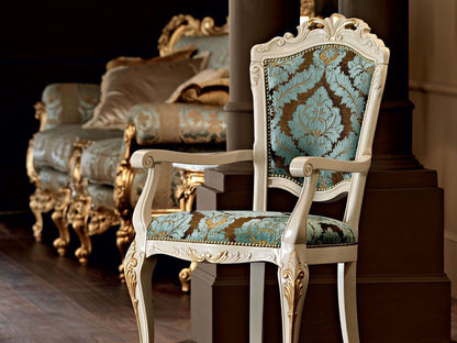 Decorative chair with ornate armrests and backrest in a room with a sofa.