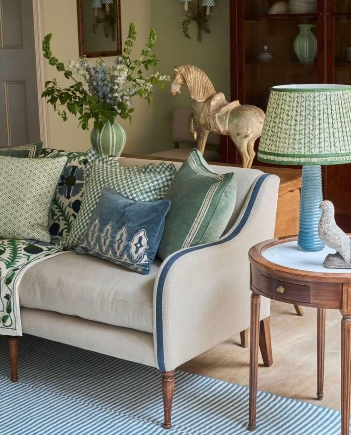 Living room with a beige sofa, decorative pillows, and a lamp.