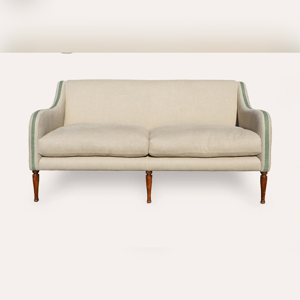 Beige sofa with green trim on a white background
