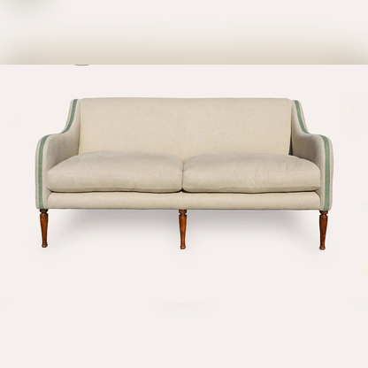 Beige sofa with green trim on a white background