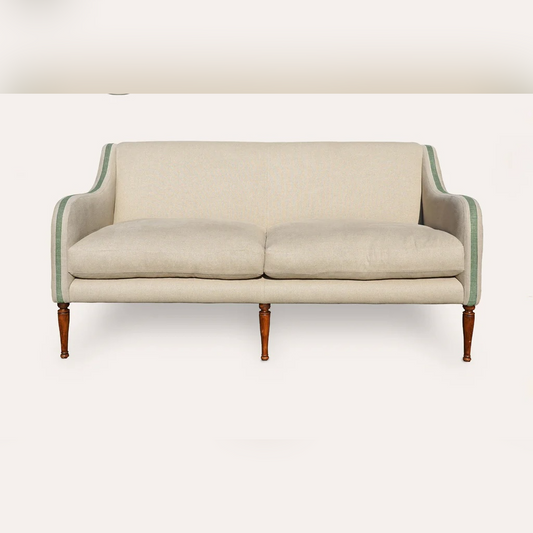 Beige sofa with green trim on a white background