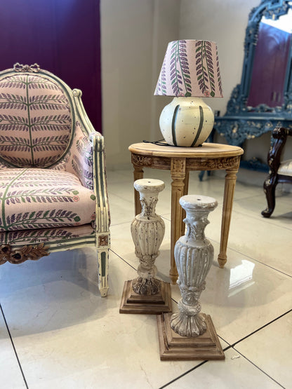 Decorative chair with a lamp and vases on a marble floor