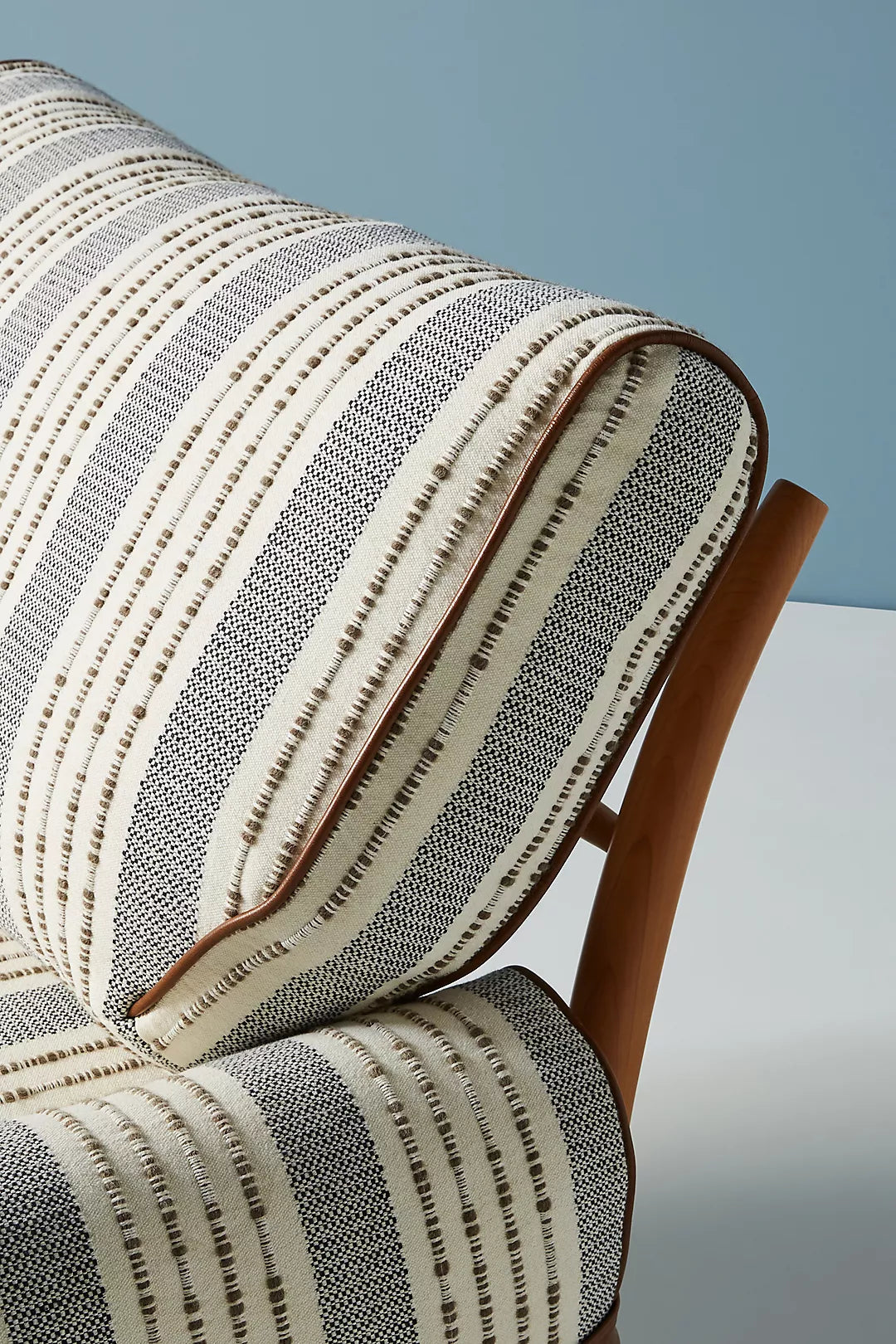 Close-up of a striped cushion on a chair with a neutral background