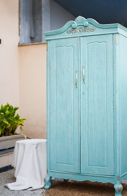 Turquoise wardrobe with decorative elements in a room setting