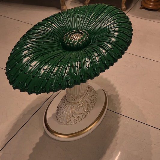 Decorative table with green top and white base on a tiled floor