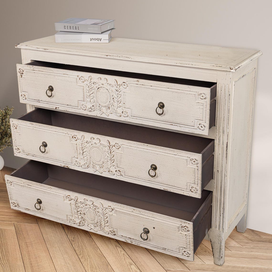 Vintage-style dresser with decorative carvings on a wooden floor.
