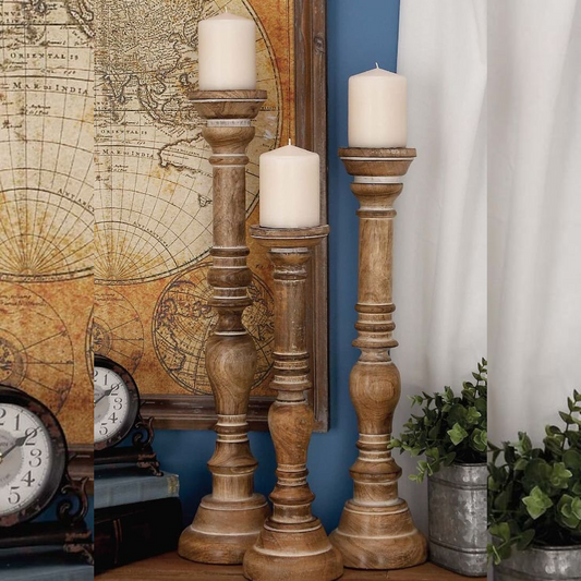Wooden candle holders with candles in front of a world map and clock on a blue wall.