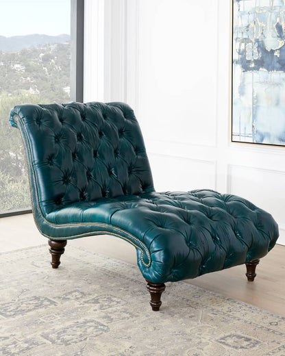 Teal tufted chaise lounge in a room with large windows.