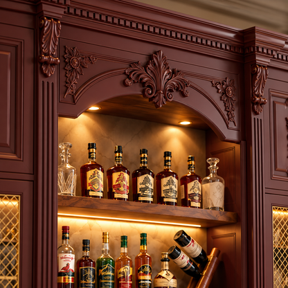 A close-up of an ornate dark reddish-brown wooden cabinet shelf displaying multiple liquor bottles, decant glass bottles, and a bottle rack, with warm interior lighting.