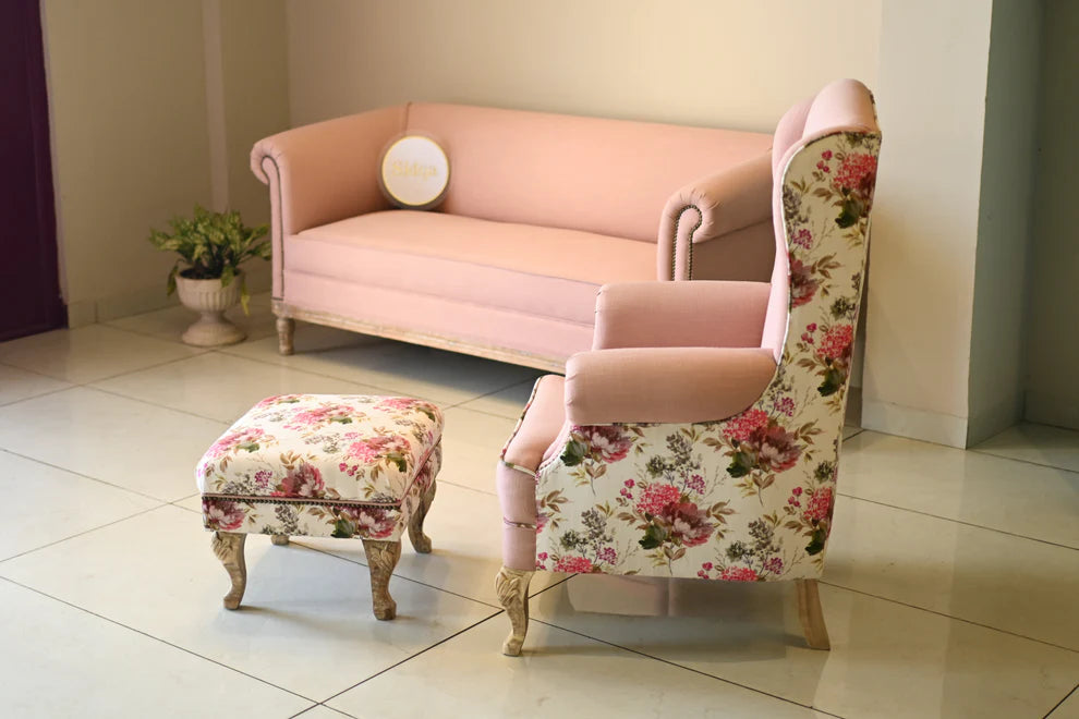 Pink floral armchair and ottoman in a room with a light-colored floor.