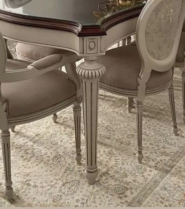 Round dining table with chairs on a patterned rug