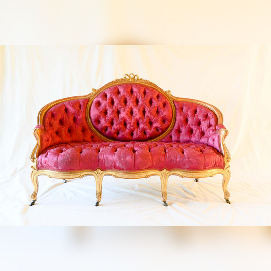 Pink tufted sofa with gold frame on a white background