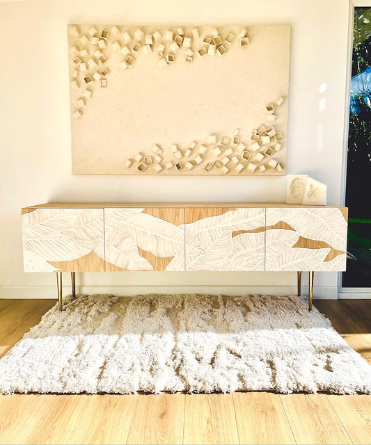 Modern console table with marble-like design in a room with decorative wall art.