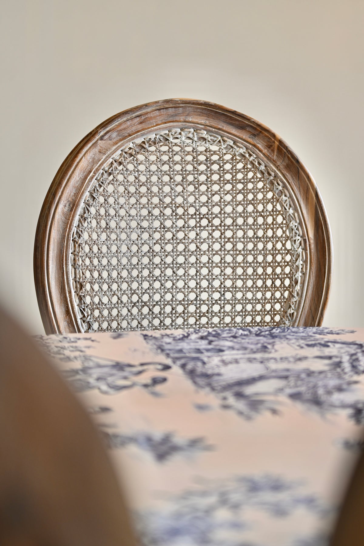 Chair with wicker backrest and patterned tablecloth