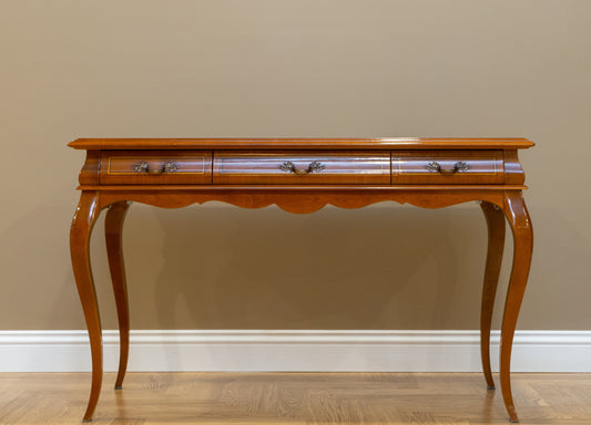 An elegant Sidqa mahogany console table with drawers and decorative legs, placed against a neutral background.