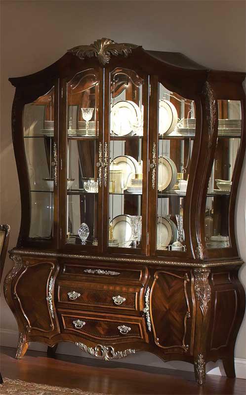 Antique mahogany grand display cabinet with silver accents, featuring glass doors and shelves, and wooden drawers.