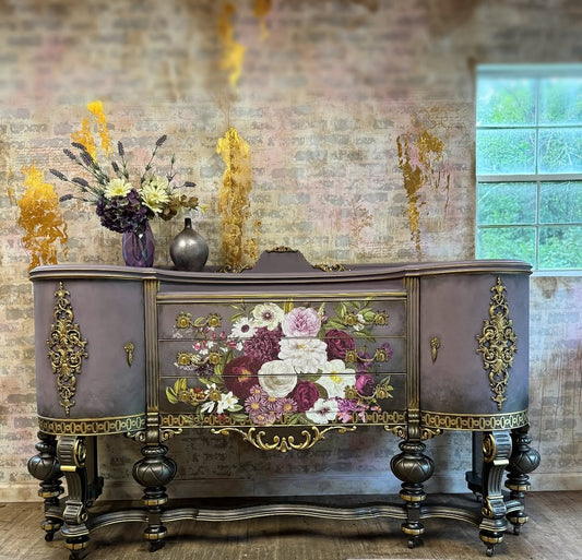 Decorative sideboard with floral design and gold accents against a textured wall.