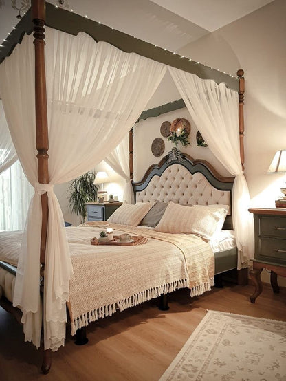 Bedroom with canopy bed, wooden headboard, and decorative pillows.