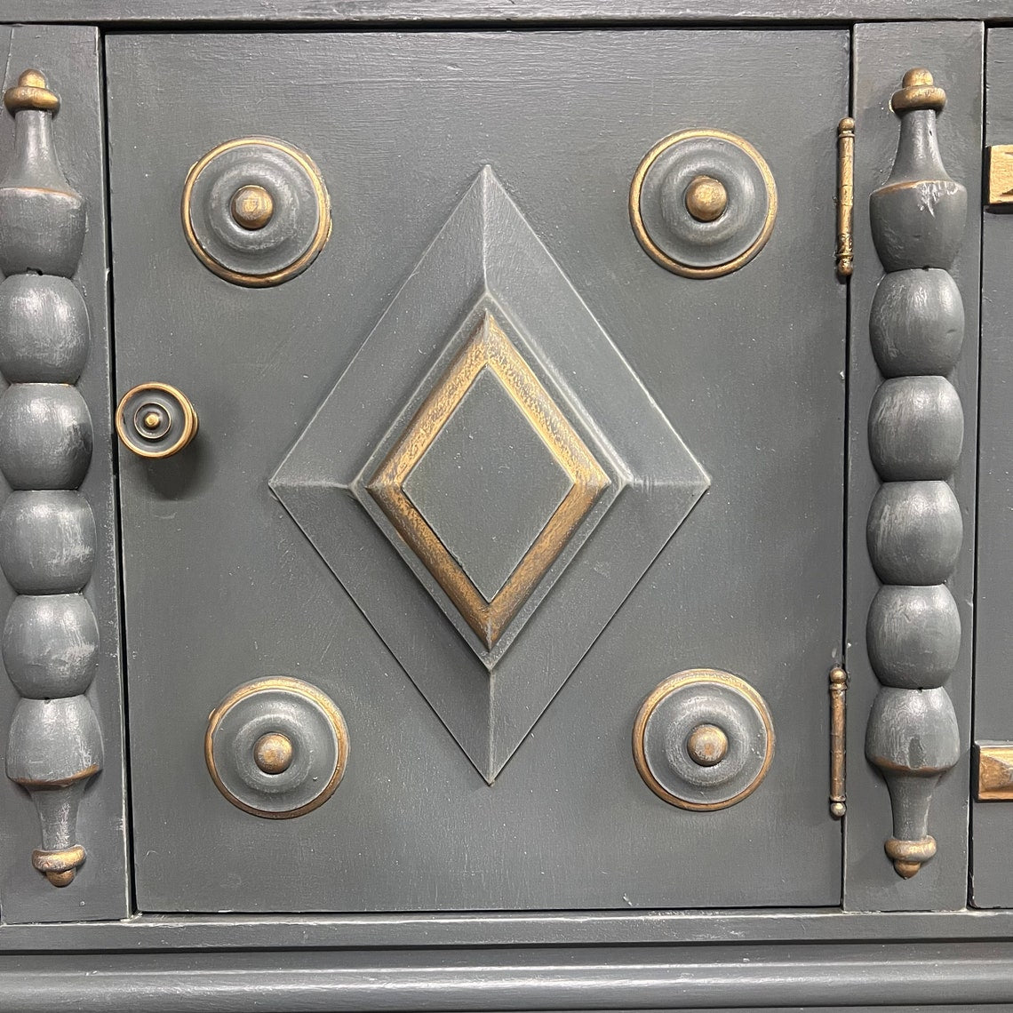Close-up of a decorative metal door with geometric patterns and gold accents.