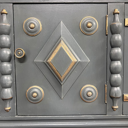 Close-up of a decorative metal door with geometric patterns and gold accents.