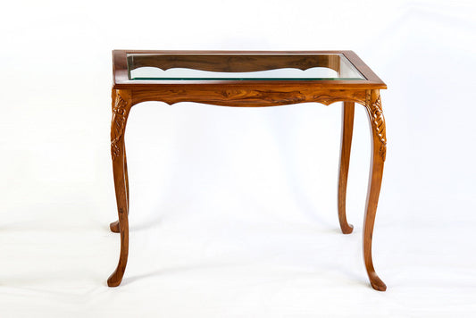 A rectangular side table with a natural polished finish, featuring curvy legs with gold carvings and a glass surface.