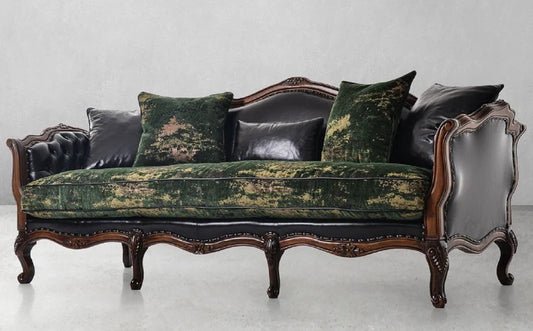 Decorative sofa with green velvet and black leather cushions on a white background